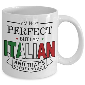May include: White ceramic coffee mug with a black and red design. The mug features the text "I'm not perfect but I am Italian and that's close enough". The text is surrounded by a black line and a red, white, and green Italian flag.