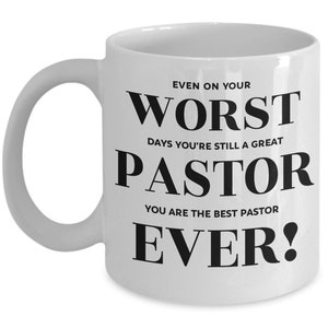 May include: White ceramic coffee mug with black text that reads "Even on your worst days you're still a great pastor. You are the best pastor ever!"