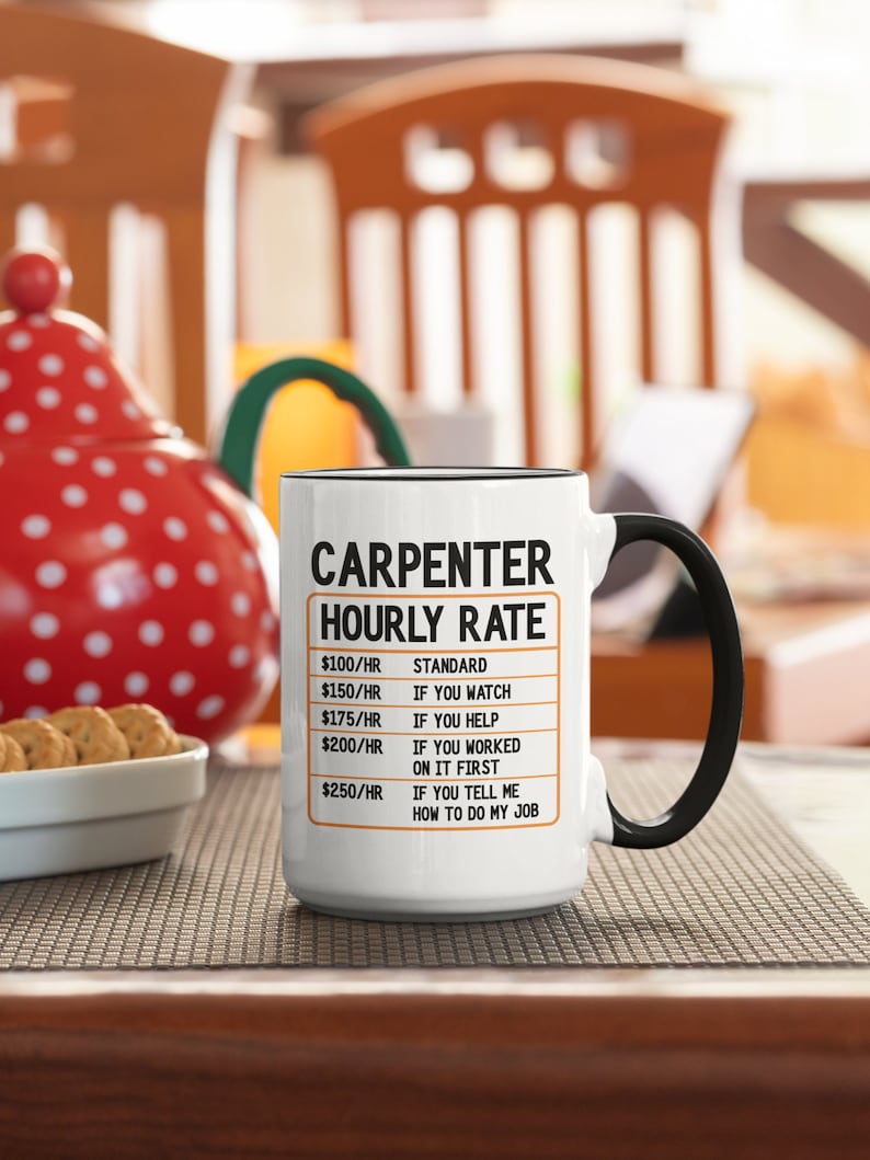 May include: White ceramic coffee mug with a black handle. The mug has a black border and the text "CARPENTER HOURLY RATE" in black. The text is followed by a list of hourly rates and descriptions, such as "$100/HR STANDARD", "$150/HR IF YOU WATCH", "$175/HR IF YOU HELP", "$200/HR IF YOU WORKED ON IT FIRST", and "$250/HR IF YOU TELL ME HOW TO DO MY JOB".