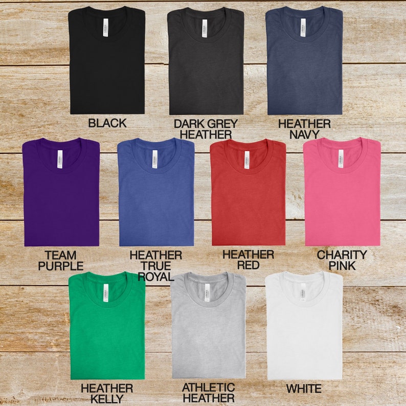 May include: A selection of t-shirts in various colors, including black, dark grey heather, heather navy, team purple, heather true royal, heather red, charity pink, heather kelly, athletic heather, and white.