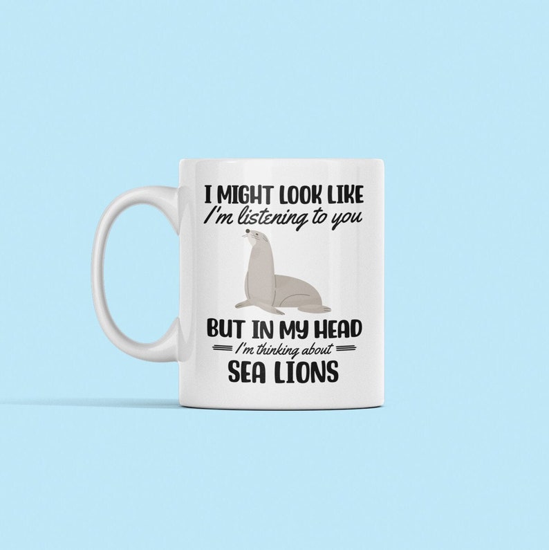 May include: White ceramic mug with a black graphic of a sea lion and the text "I might look like I'm listening to you but in my head I'm thinking about sea lions."