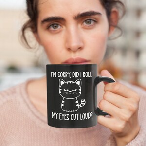 May include: Black coffee mug with a white cartoon cat and the text "I'm sorry, did I roll my eyes out loud?"