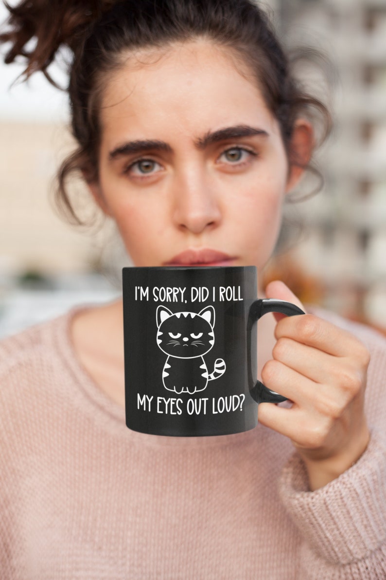 May include: Black coffee mug with a white cartoon cat and the text "I'm sorry, did I roll my eyes out loud?"