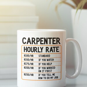May include: White ceramic coffee mug with a black and orange design. The mug reads "Carpenter Hourly Rate" with a list of hourly rates and reasons for the rate increase.