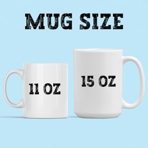 May include: Two white ceramic mugs, one labeled "11 OZ" and the other "15 OZ", are displayed against a light blue background. The text "MUG SIZE" is printed in bold, black letters above the mugs. The mugs are empty and ready for use.