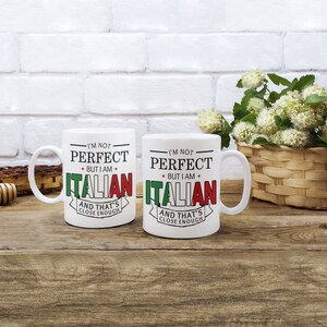 May include: Two white ceramic mugs with black text and red, green, and white accents. The text on the mugs reads "I'm not perfect, but I am Italian, and that's close enough."