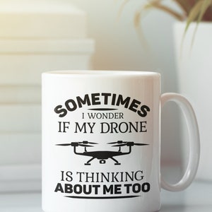 Op de afbeelding: Een witte keramische mok met een zwarte afbeelding waarop staat "Sometimes I wonder if my drone is thinking about me too". De afbeelding bevat ook een zwart silhouet van een drone.