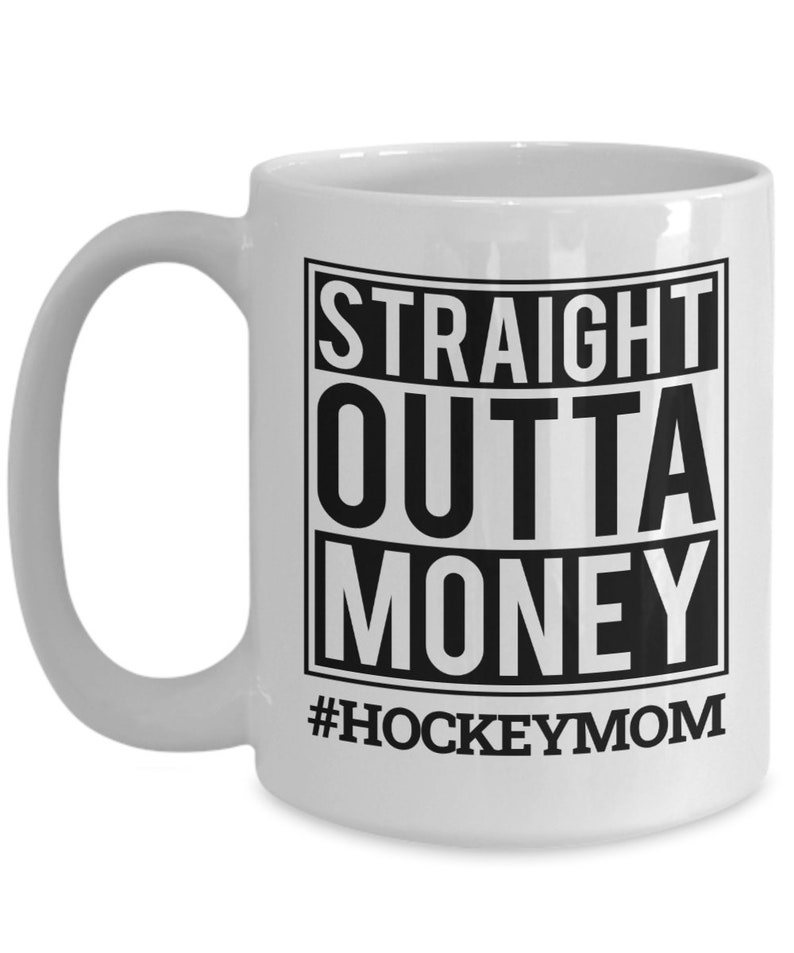 May include: White ceramic coffee mug with a black graphic that reads "Straight Outta Money #HockeyMom".