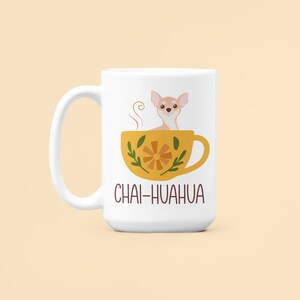 May include: White ceramic mug with a yellow teacup and a chihuahua inside. The teacup has a floral design and the text "Chai-huahua" is printed on the mug.