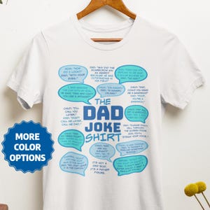 May include: White t-shirt with a blue and light blue design featuring a variety of dad jokes in speech bubbles. The text "The Dad Joke Shirt" is in large blue letters.