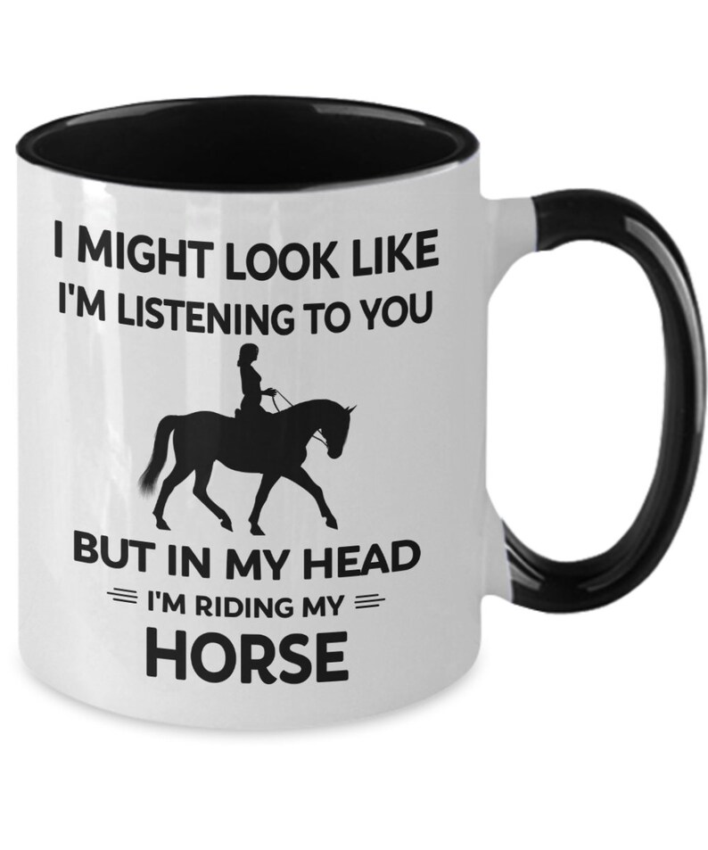 May include: White ceramic mug with a black rim and handle. The mug has a black silhouette of a person riding a horse with the text "I might look like I'm listening to you but in my head I'm riding my horse."