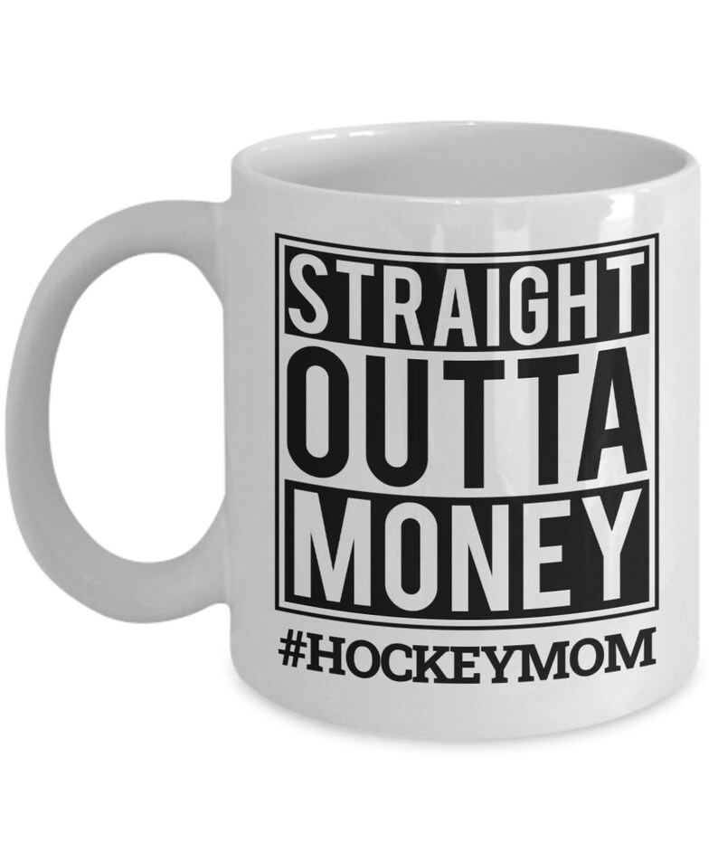 May include: White ceramic coffee mug with a black graphic that reads "STRAIGHT OUTTA MONEY #HOCKEYMOM".