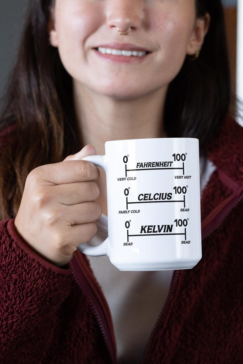 Op de afbeelding: Witte keramische mok met een zwart temperatuurschaalontwerp. De mok heeft schalen voor Fahrenheit, Celsius en Kelvin, met temperatuurbereiken van "Zeer koud" tot "Zeer heet" en "Dood".