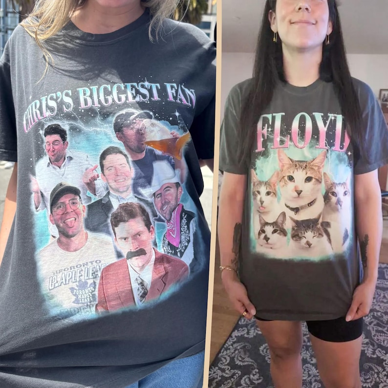 May include: A charcoal gray t-shirt featuring a collage of a man in various poses and outfits with the text CHRIS'S BIGGEST FAN, alongside a second charcoal gray t-shirt displaying a group of five cats and the word FLOYD in pink and white.