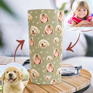May include: A cylindrical tumbler with a sage green background featuring a repeating pattern of small white hearts, starbursts, and alternating photographic portraits of a young child and a golden retriever puppy with its tongue out.