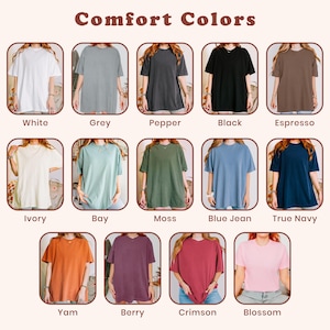May include: A color chart titled Comfort Colors displaying twelve short-sleeve t-shirts in various shades: white, grey, pepper, black, espresso, ivory, bay, moss, blue jean, true navy, yam, berry, crimson, and blossom, each labeled with its color name.
