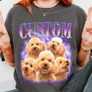 A person wearing a grey t-shirt with a graphic design featuring five happy poodle dogs.