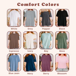May include: A color chart featuring twelve short-sleeve t-shirts labeled Comfort Colors. The shirts are displayed in white, grey, pepper, black, espresso, ivory, bay, moss, blue jean, navy, berry, and blossom. Each shirt is shown in a rounded frame.