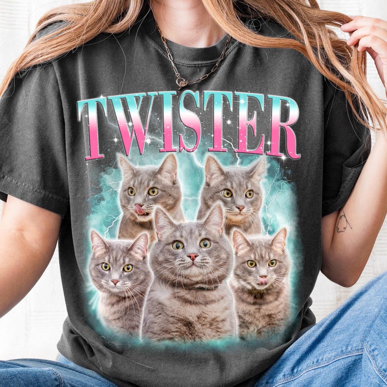 A person wearing a black t-shirt with a graphic design featuring five cats with the word "Twister" written above them.