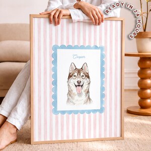 以下が含まれることがあります： 舌を出した茶色と白のハスキー犬の水彩画イラストが描かれた額入りプリント。犬は水色のスカラップ模様の枠内に配置され、背景は淡いピンクと白の縦縞模様になっている。