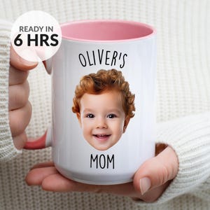 May include: White ceramic mug with a pink interior and handle. The mug features a photo of a child with the text "OLIVER'S MOM". The words "READY IN 6 HRS" are also printed on the mug.