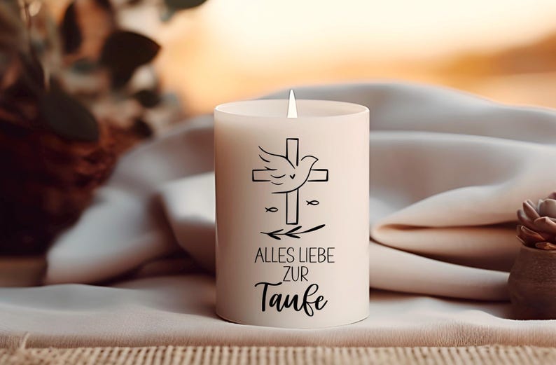 May include: A white pillar candle with a cross and dove design, along with the German text "ALLES LIEBE ZUR Taufe". The candle has a lit wick and is set against a soft, neutral background.