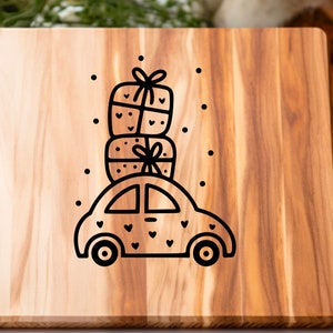 May include: A wooden cutting board with a black and white illustration of a car with a stack of presents on top. The car is decorated with small hearts.