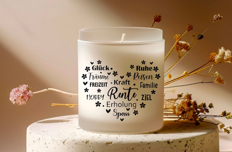 May include: White frosted glass candle with black text that reads "*Gl&uuml;ck. *Tr&auml;ume *Reisen *FREIZEIT. Kraft. *HOBBY Rente. ZIEL *Erholung *Spass *" with small black flower symbols around the text.