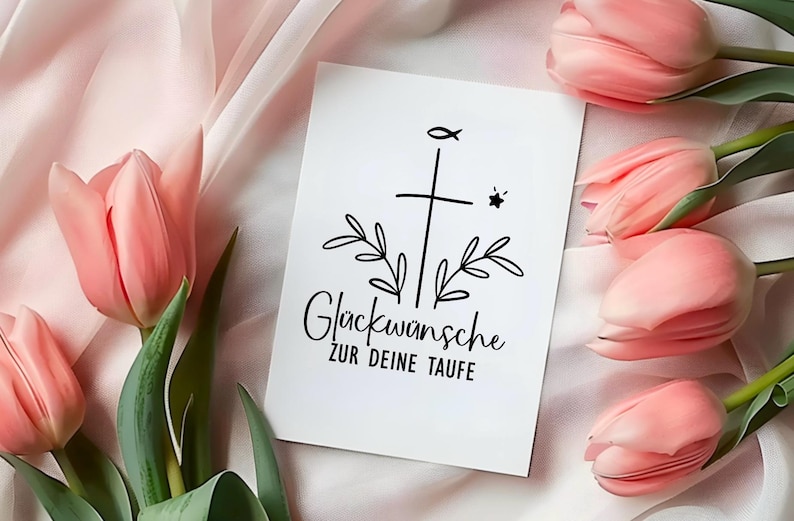 May include: A white card with a black cross, fish, and star design, surrounded by leaves and the German text "Gl&uuml;ckw&uuml;nsche zur deine Taufe." Pink tulips with green stems and leaves are arranged around the card on a pink fabric.