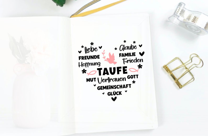 May include: A white notebook with black text that reads "*liebe FREUNDE Hoffnung * Glaube FAMILIE Frieden *TAUFE MUT Vertrauen GOTT GEMEINSCHAFT GL&Uuml;CK * *" with a pink dove and fish graphic.