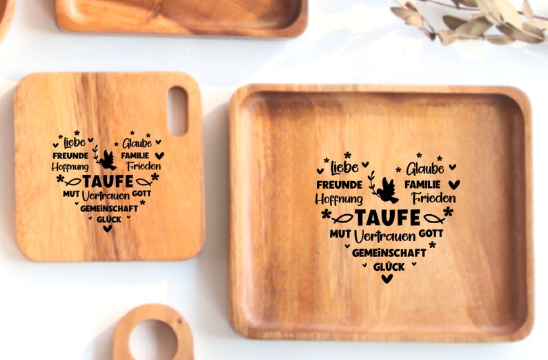 May include: Two wooden serving trays with a black engraved design. The design includes the words "Liebe", "Freunde", "Hoffnung", "Glaube", "Familie", "Frieden", "Taufe", "Mut", "Vertrauen", "Gott", "Gemeinschaft", and "Gl&uuml;ck".