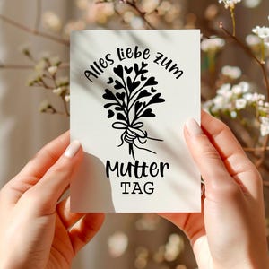 May include: A white card with black text and a black illustration of a bouquet of hearts. The text reads "Alles Liebe zum Mutter Tag".