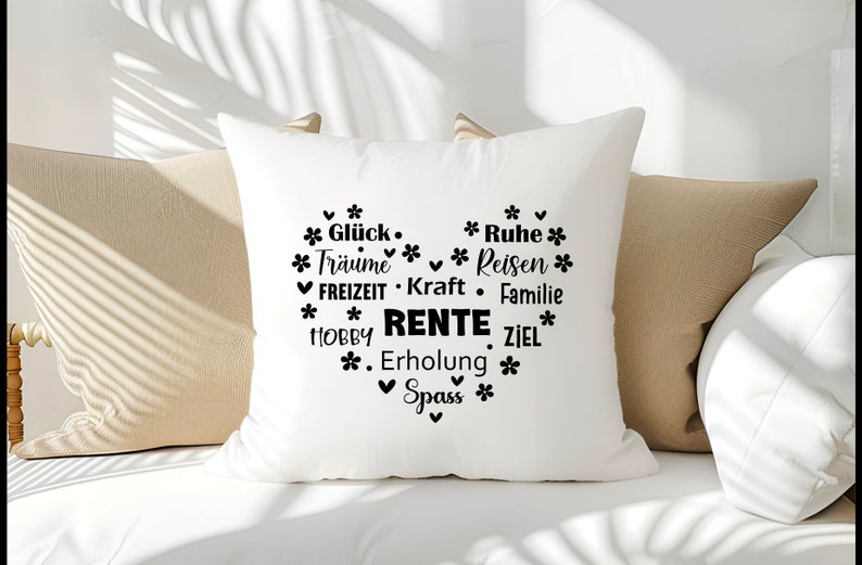 May include: White pillow with black text that reads "Gl&uuml;ck. * Ruhe * *Tr&auml;ume Reisen * FREIZEIT Kraft Familie *HOBBY RENTE ZIEL* *. Erholung * ✓ Spass *" in a heart shape.