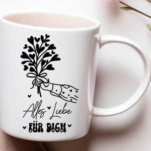 May include: White ceramic mug with a black and white illustration of a hand holding a bouquet of hearts. The text "Alles Liebe f&uuml;r Dich" is printed on the mug.