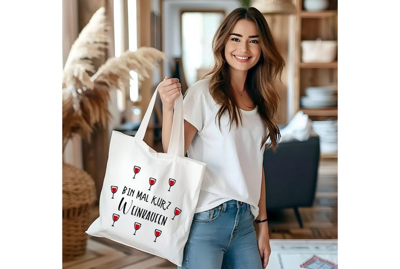 May include: White tote bag with a black and red design. The bag has the text "Bin mal kurz Wein kaufen" and several red wine glasses printed on it.