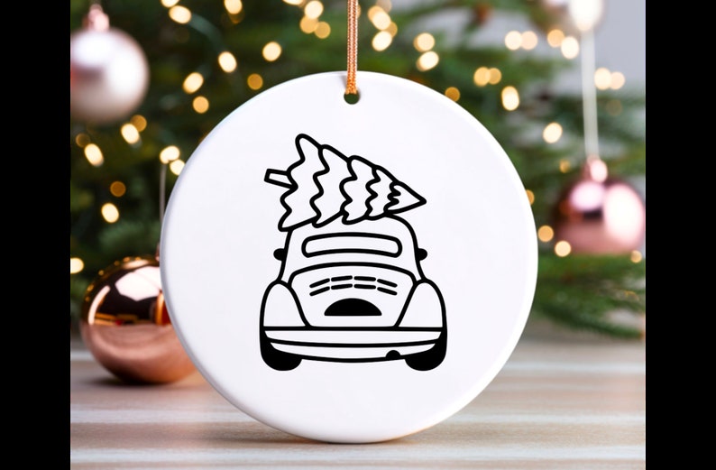 May include: A white ceramic ornament with a black line drawing of a car with a Christmas tree on top.