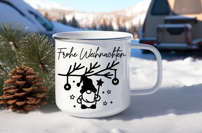May include: White enamel mug with a black silhouette of a gnome holding a star on a branch with ornaments. The text "Frohe Weihnachten" is printed on the mug.