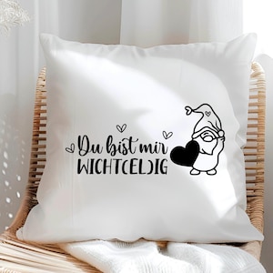 May include: White pillow with black text that reads "Du bist mir wichtig" and a black and white illustration of a gnome holding a heart.