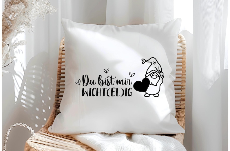 May include: White pillow with black text that reads "Du bist mir wichtig" and a black and white illustration of a gnome holding a heart.