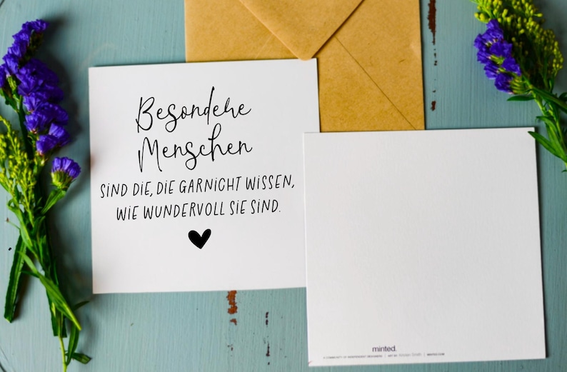 May include: A white card with black text that reads "Besondere Menschen sind die, die garnicht wissen, wie wundervoll sie sind."  There is a small black heart at the bottom of the card.
