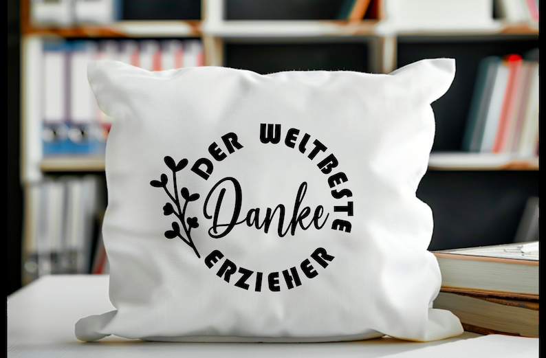 K&ouml;nnte beinhalten: Wei&szlig;es Kissen mit schwarzem Text, der "Der Weltbeste Danke Erzieher" lautet, was &uuml;bersetzt "Der beste Erzieher Danke" bedeutet.
