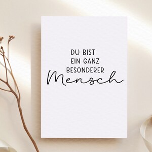 Puede incluir: Una tarjeta blanca con texto negro que dice "Du bist ein ganz besonderer Mensch", que se traduce como "Eres una persona muy especial".