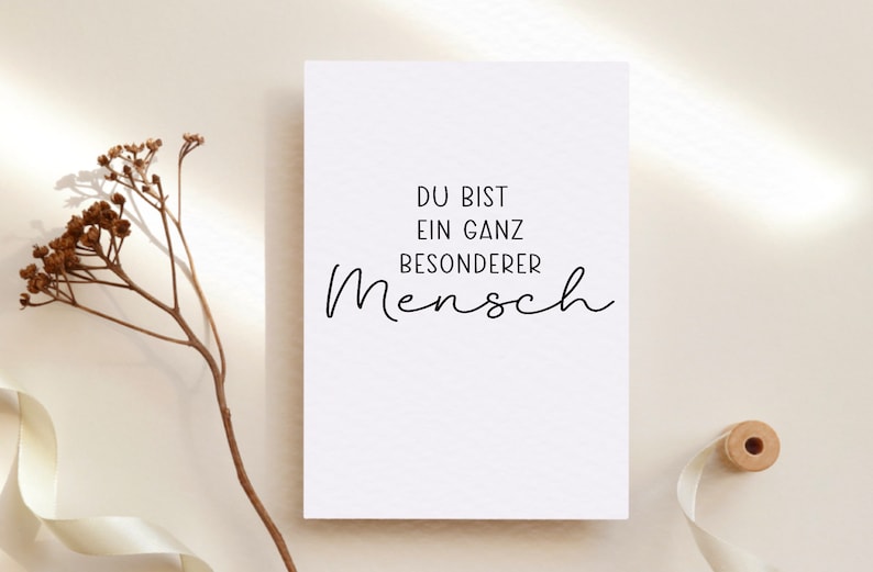 Puede incluir: Una tarjeta blanca con texto negro que dice "Du bist ein ganz besonderer Mensch", que se traduce como "Eres una persona muy especial".