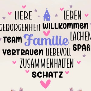 Peut inclure: Un fond blanc avec une icône de maison violette au centre. Autour de la maison se trouvent les mots "Liebe", "Geborgenheit", "Willkommen", "Team", "Familie", "Vertrauen", "Liebevoll", "Zusammenhalten", "Schatz", "Leben", "Lachen", et "Spaß". Des cœurs roses et des étoiles sont dispersés autour des mots.
