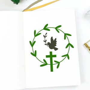 May include: A green wreath with a dove carrying an olive branch and a cross in the center.