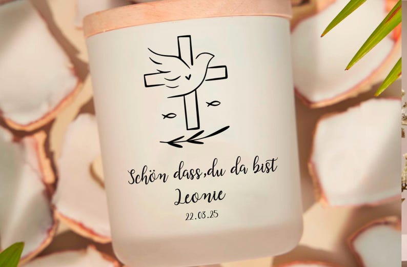 Pu&ograve; includere: Candela bianca con un coperchio in legno. La candela presenta un design in bianco e nero di una colomba con le ali spiegate, una croce e due simboli di pesci. Il testo "Sch&ouml;n dass du da bist Leonie 22.03.25" &egrave; stampato sotto il design.