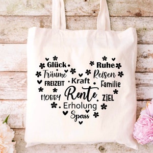 May include: White canvas tote bag with a black heart design. The heart is filled with text that says "Gl&uuml;ck, Tr&auml;ume, FREIZEIT, HOBBY, Rente, Erholung, Spass" and "Ruhe, Reisen, Kraft, Familie, ZIEL".