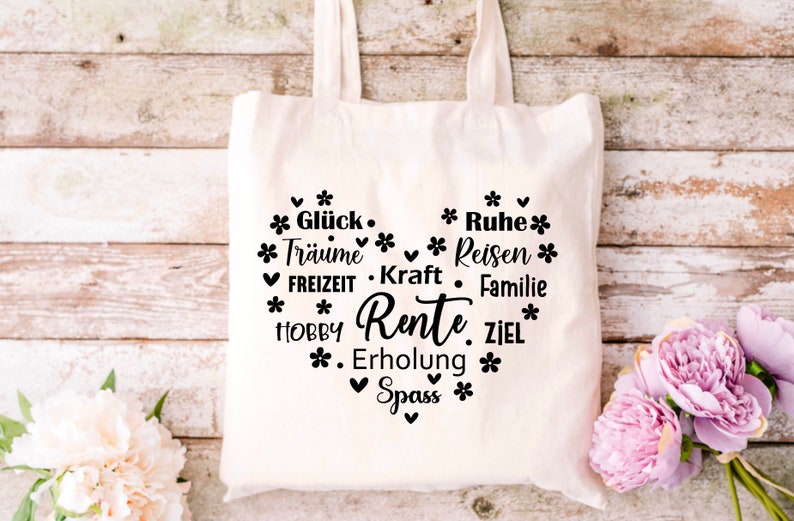 May include: White canvas tote bag with a black heart design. The heart is filled with text that says "Gl&uuml;ck, Tr&auml;ume, FREIZEIT, HOBBY, Rente, Erholung, Spass" and "Ruhe, Reisen, Kraft, Familie, ZIEL".