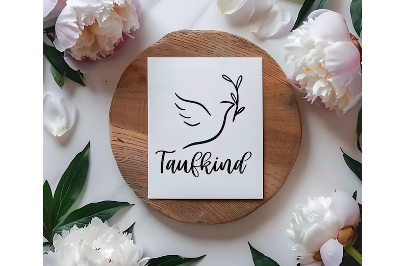May include: A white card with a black dove illustration holding an olive branch, with the word "Taufkind" in script. The card rests on a wooden slice, surrounded by white peony flowers and green leaves.
