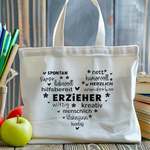 K&ouml;nnte beinhalten: Wei&szlig;e Stofftasche mit schwarzem Text, der "SPONTAN super liebevoll hilfsbereit * ERZIEHER * nett humorvoll * HERZLICH wunderbar witzig * kreativ ✓ menschlich * Wahnsinn * lustig" lautet.